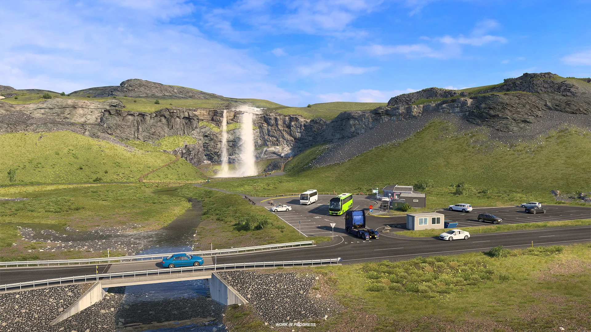 A waterfall drops down a cliff beside a car park and the main road