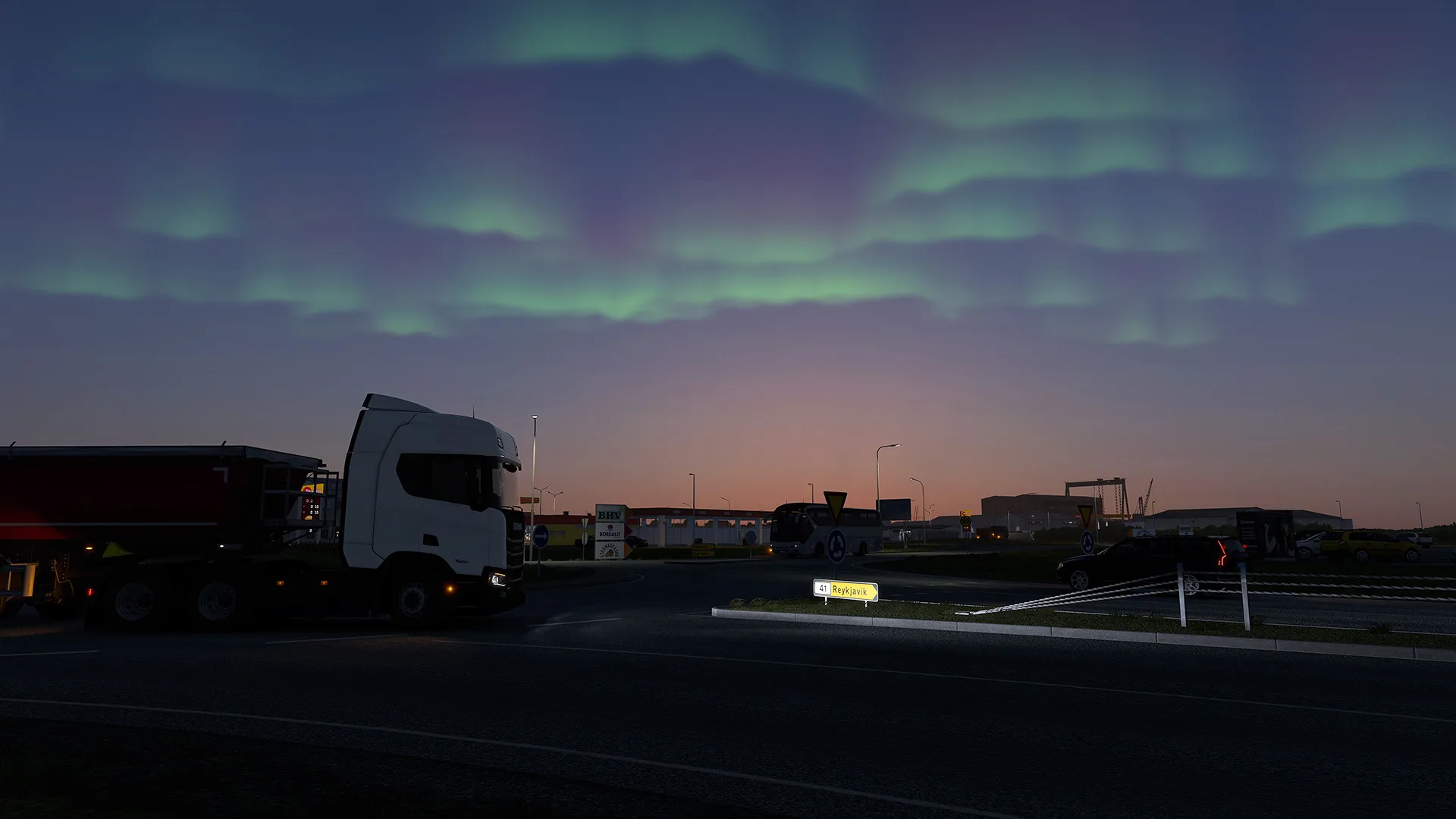 A truck parked at dusk under green Northern Lights