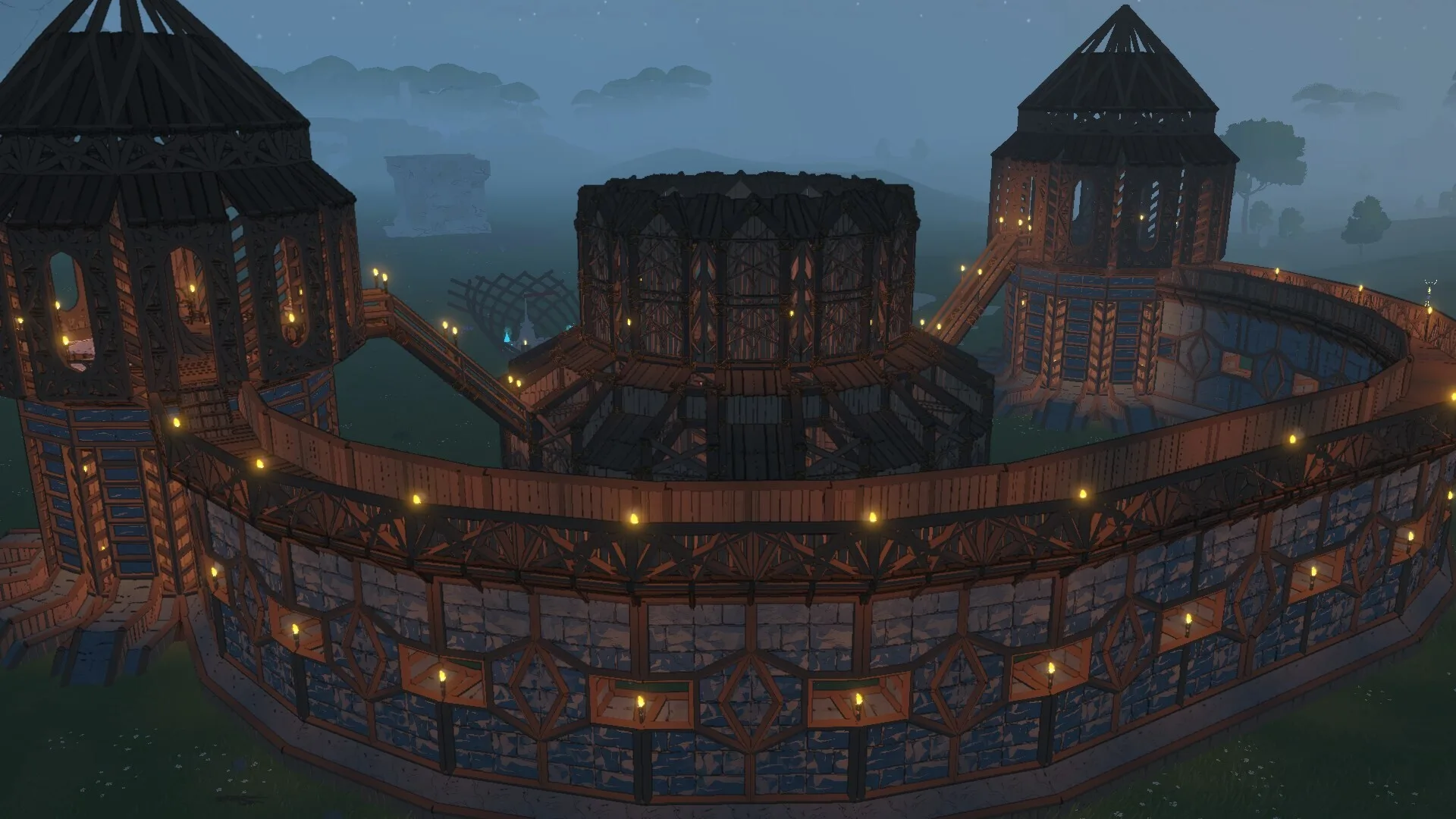 A walled stronghold with three round towers, lit by lanterns at dusk